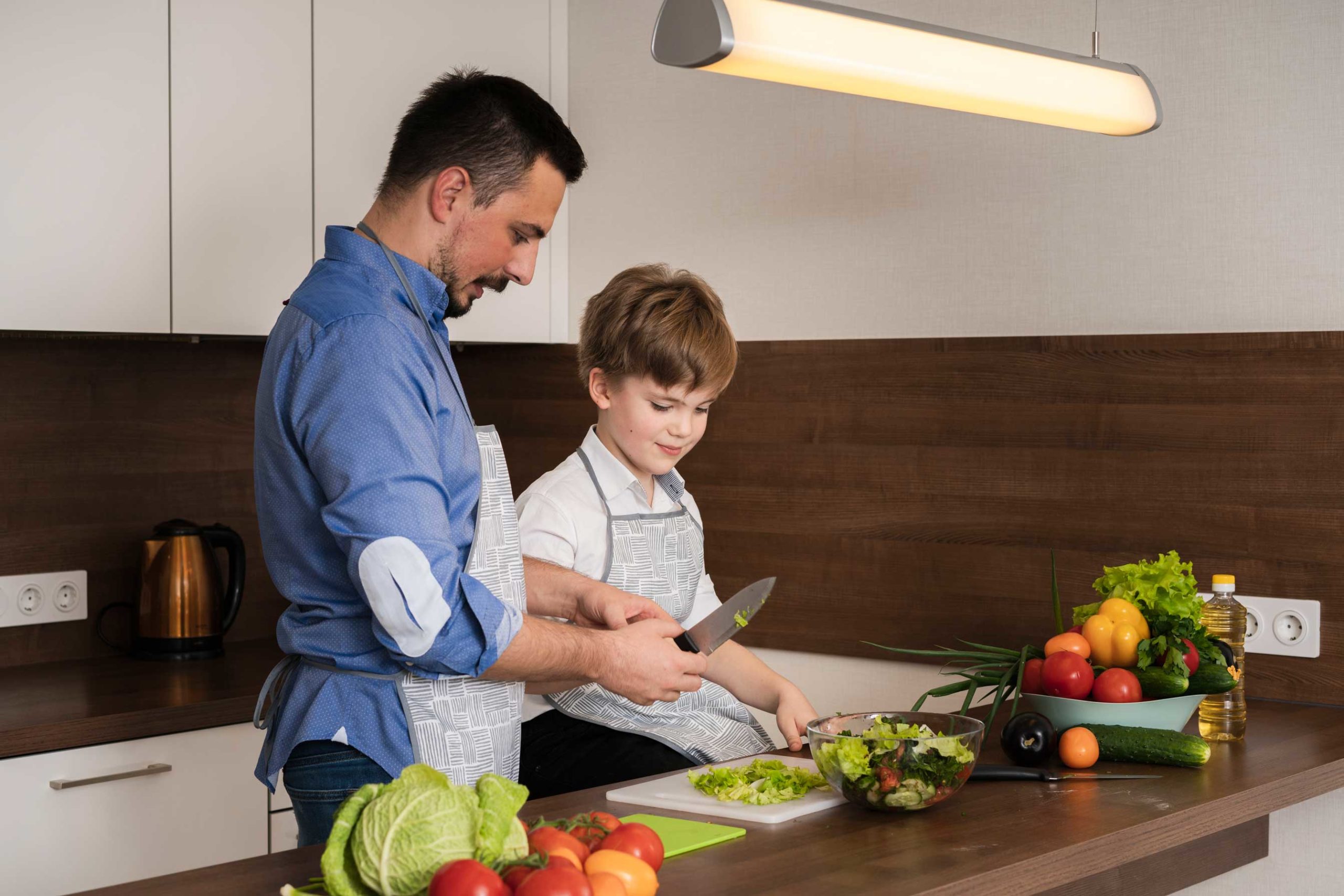 padre e hijo cocinando ensalada