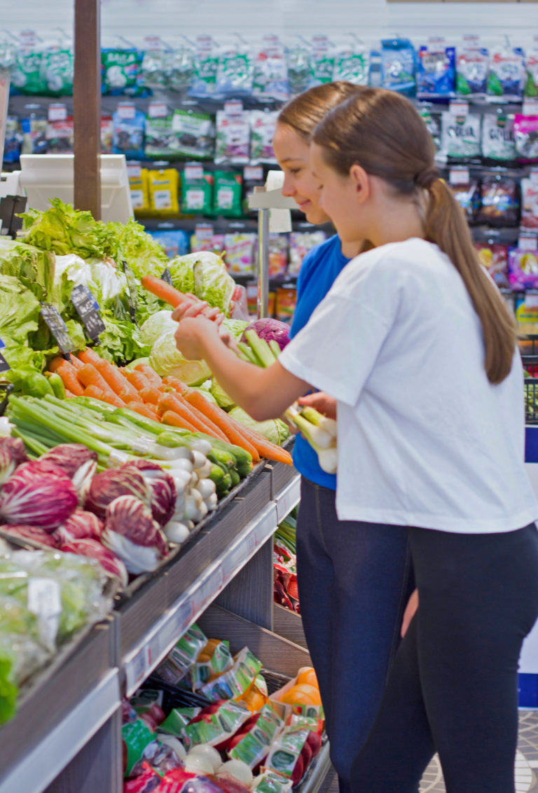 niñas comprando verduras en el supermercado